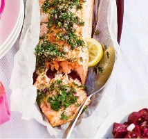 a piece of pink salmon with dill, parsley and lemon 